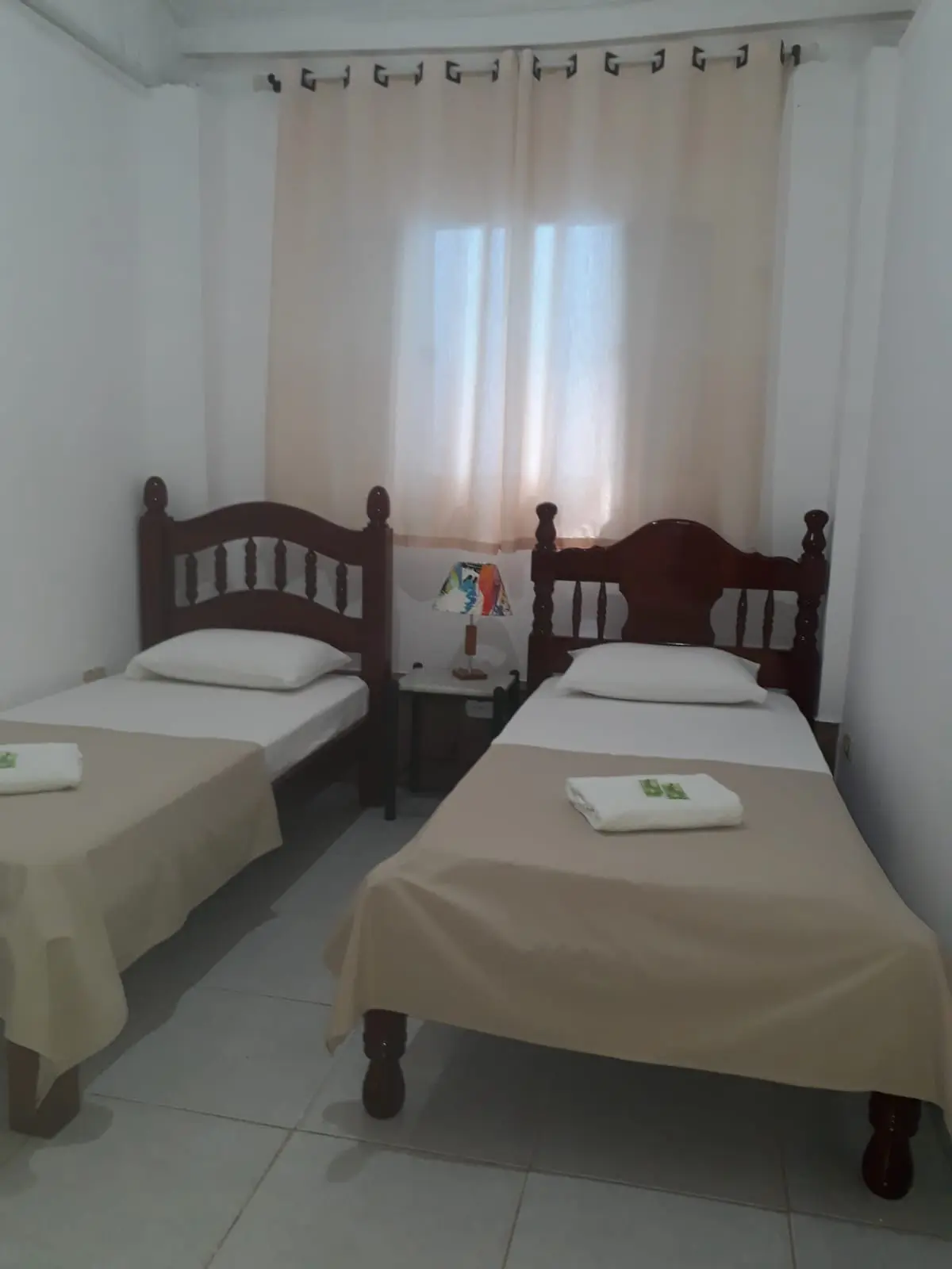 Quarto com duas camas de solteiro e cortina