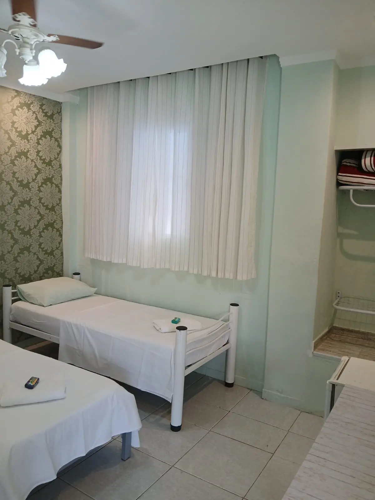 Quarto claro com camas de solteiro e ventilador de teto