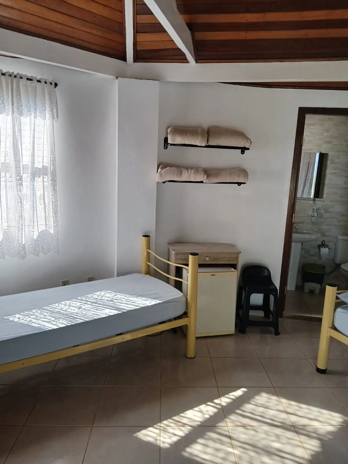 Quarto com forro de madeira e cama de solteiro