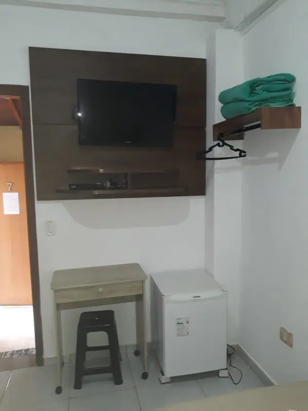Quarto com TV, frigobar e cabideiro
